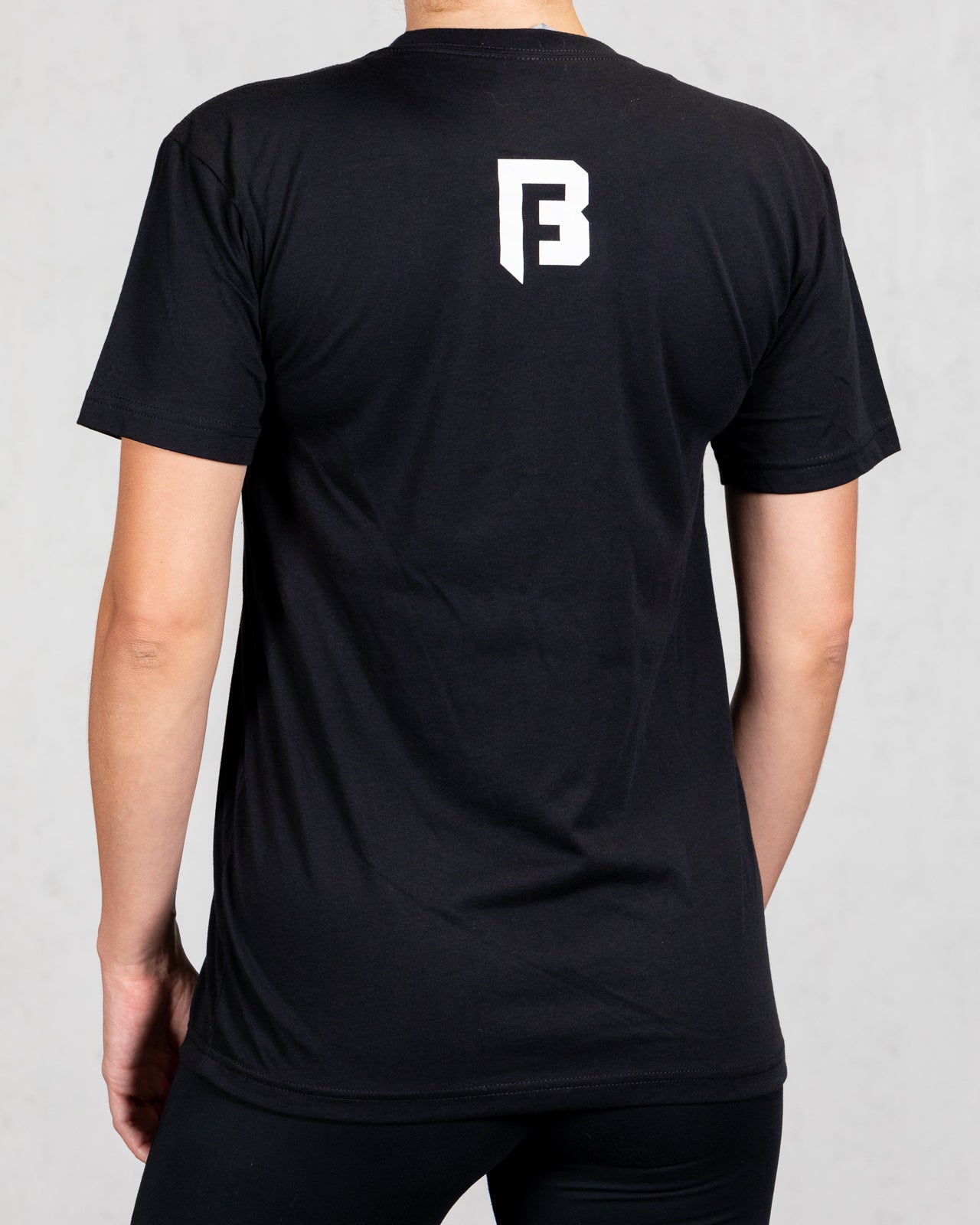 woman wearing black trucker tee back view