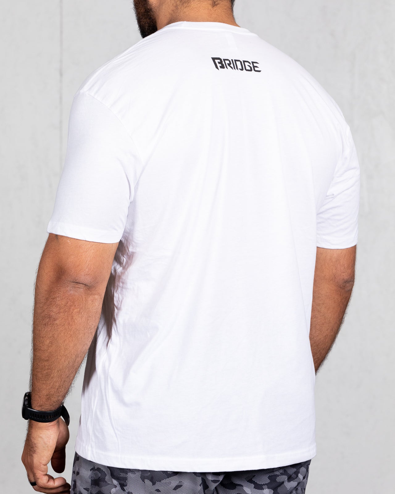 man wearing white big beefy brand shirt from back