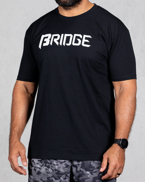 man wearing black squad tee with bridge on the front