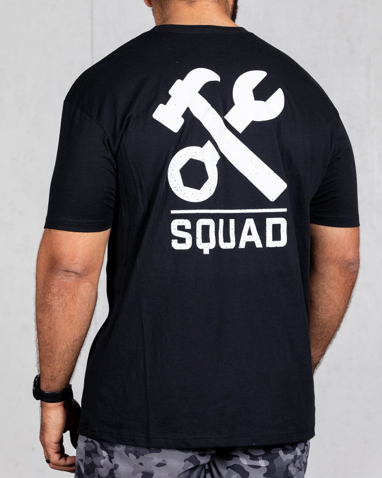 man wearing black squad tee from back