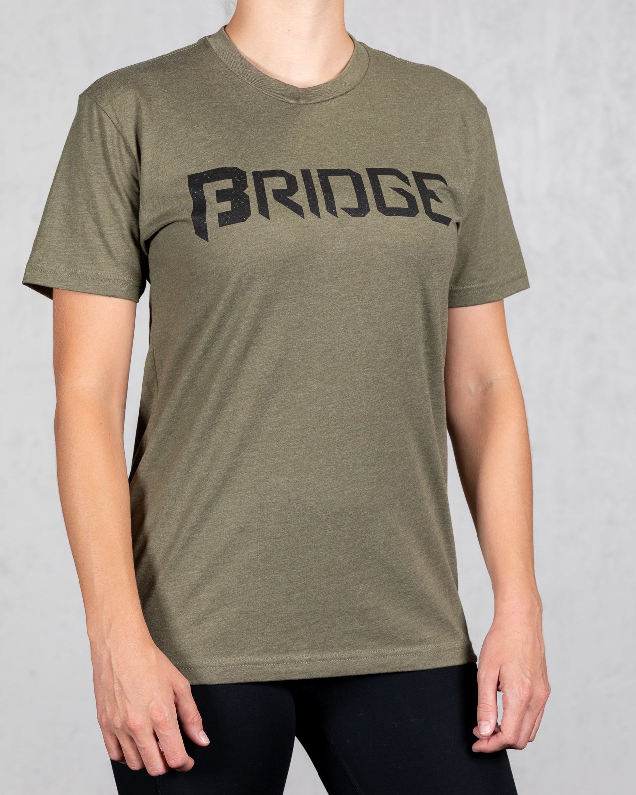 woman wearing military green squad tee with bridge on the front