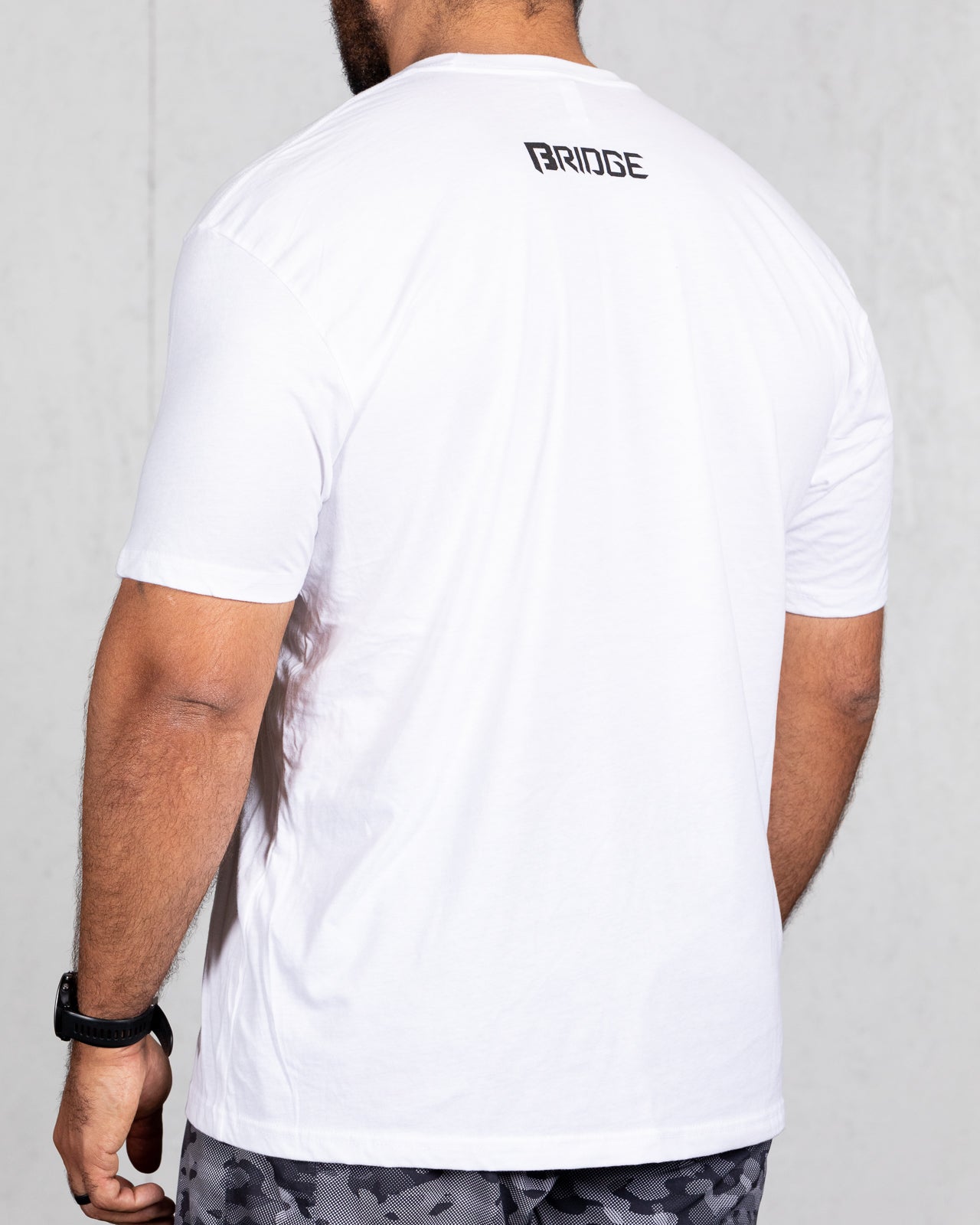 man wearing white big beefy brand shirt from back 