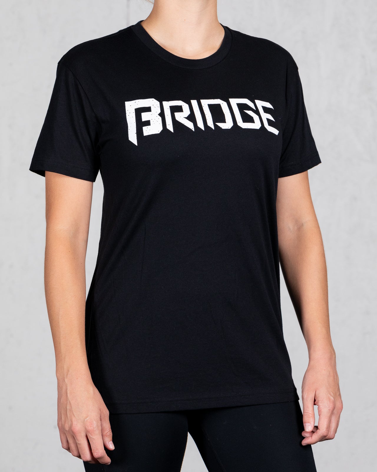 woman wearing black squad tee with bridge on the front