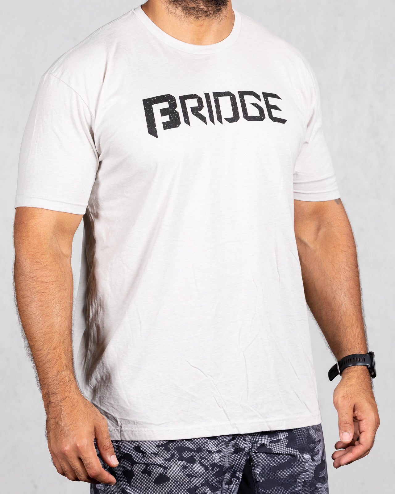 man wearing sand colored squad tee with bridge on the front