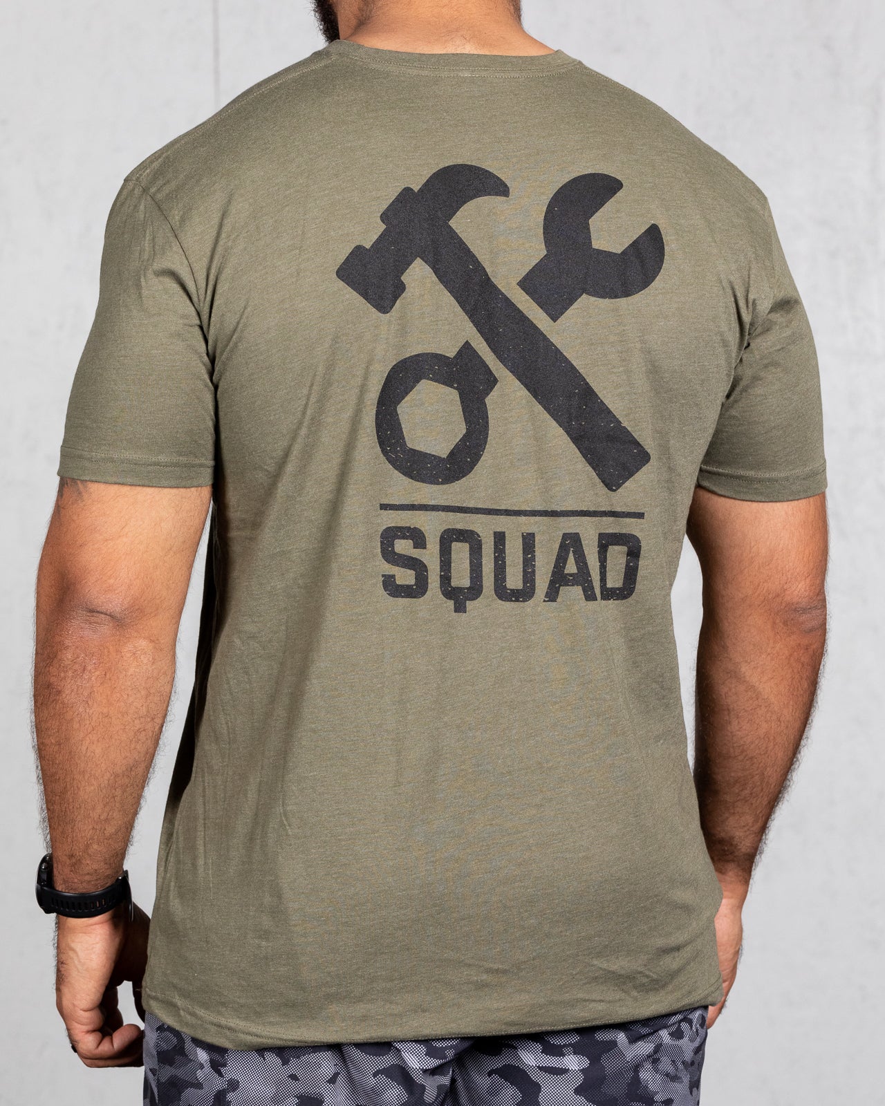 man wearing military green squad tee from back